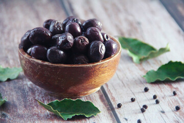 black canned olives in a wooden plate