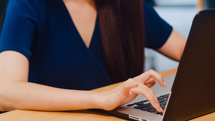 Successful beautiful executive Asia young businesswoman smart casual wear watching tutorial about creative ideas at laptop computer during working process in modern office workplace. Close up shot.