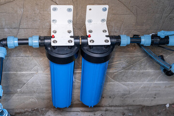 Two blue filter flasks are embedded in the central water supply system of a private house