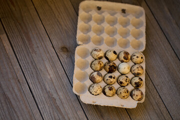 Quail eggs in a package on background.