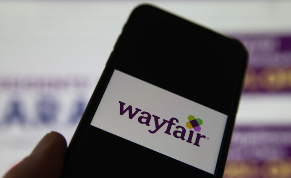 Viersen, Germany - February 9. 2021: Closeup of smartphone screen with logo lettering of wayfair , blurred website background