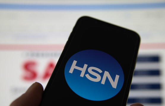 Viersen, Germany - February 9. 2021: Closeup of smartphone screen with logo lettering of HSN home shopping network , blurred website background