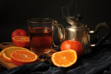 Orange tea. Citrus. Teapot with a cup. Low key.Tea time.