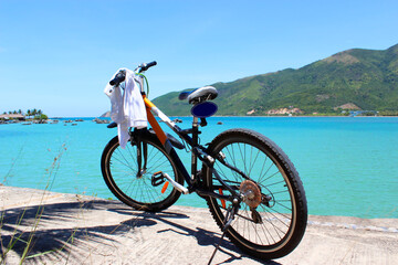 Fototapeta premium bike stands on the seashore with mountains in the background