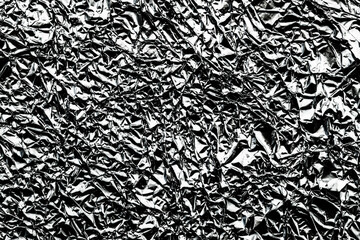 Monochrome pattern of crumpled silver aluminum foil background.