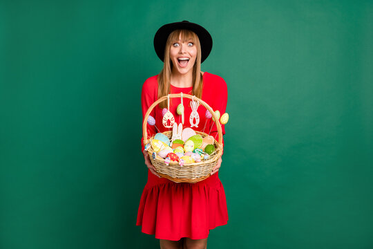 Photo of young happy excited smiling cheerful girl hold basket full of easter eggs isolated on green color background