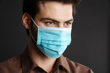 Close up of a confident young man in medical protective mask