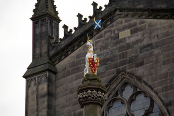 A heraldic unicorn on Edinburgh's Royal Mile. A Royal Unicorn, symbol of Scottish Royalty, at the apex and colourful coats of arms embedded at the plinth top. © Oxana