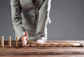Business woman hand stop domino effect
