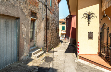 Fototapeta na wymiar Narrow street of the charming Tuscany village Mommio Castello, at the top of the hill of Versilia, province of Lucca, Italy