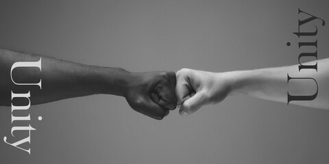 Bump. African and caucasian hands gesturing on gray studio background. Tolerance and equality,...