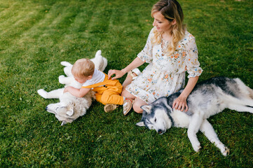 Mother and son posing with two dogs on the grass