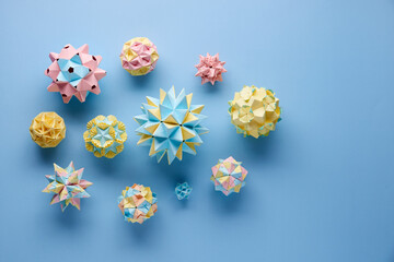 Set of multicolor handmade modular origami balls or Kusudama Isolated on blue background. Visual...