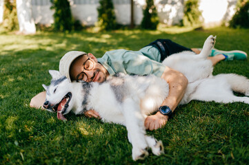 A lovely man lying with a dog on the grass