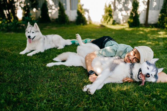 A lovely man and two dogs posing on the grass