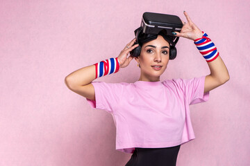 Pretty slim sporty brunette athletic model girl doing aerobic exercises gymnastics workout routine wearing vr glasses - Beautiful young sportive attractive caucasian woman posing in pink gym outfit 