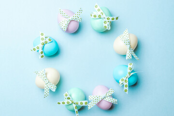 Fototapeta na wymiar Easter flat. Colorful egg with tape ribbon on pastel blue background in Happy Easter decoration. Spring holiday top view concept.