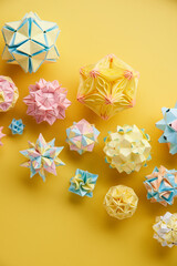 Set of multicolor handmade modular origami balls or Kusudama Isolated on yellow background. Visual...