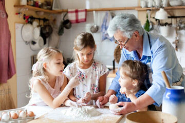 Thuis koken. Familie plezier samen. Oma en kinderen bakken brood, maken paastaart en vakantiediner in een gezellige keuken. Kinderen chef-kok. Lifestyle authentieke momenten. Openhartige ware emoties