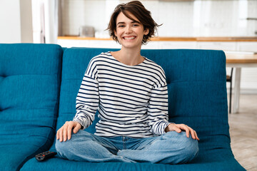 Happy beautiful woman smiling while sitting on couch