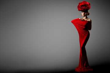 Fashion Woman in Red Dress Rose Flower Crown Hairstyle. Elegant Sexy Model in Floral Hat Bodycon Gown. Copy Space. Gray Studio Background
