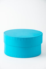 Close-up of round blue box, on white background, vertically, with copy space