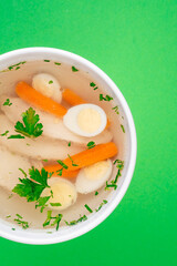 broth with chicken and egg on a white plate on a green background. close-up. photo for clipping. for the menu
