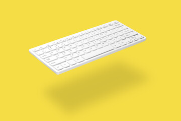. White computer keyboard levitating on yellow background, shadow visible. The concept of modern...