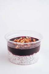 chia pudding with blueberries in plastic container on green background. Top view. Close up. Photo for clipping, for the menu