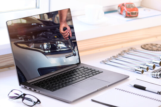 . Car repair courses. On the table are a computer and tools for car repair. Online learning
