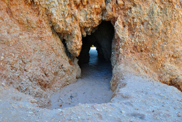Close Up of Small Cave in Rock Cliff on Sandy Beach 