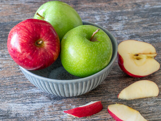 Plate with fresh ripe apples on a wooden background
