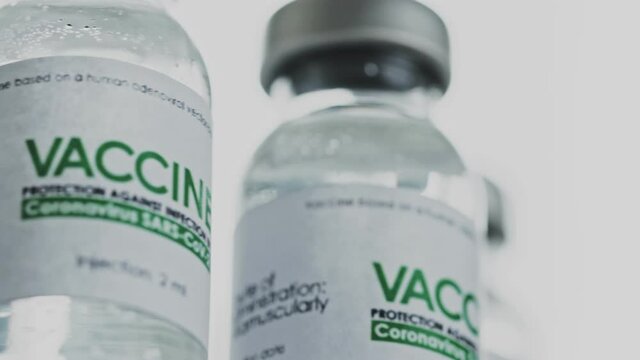 Looped. Vials of vaccine for COVID-19 coronavirus cure are slowly rotated in research lab. Vaccination, injection, clinical trial during pandemic. Flacons, vials are spinning clockwise. Closeup macro