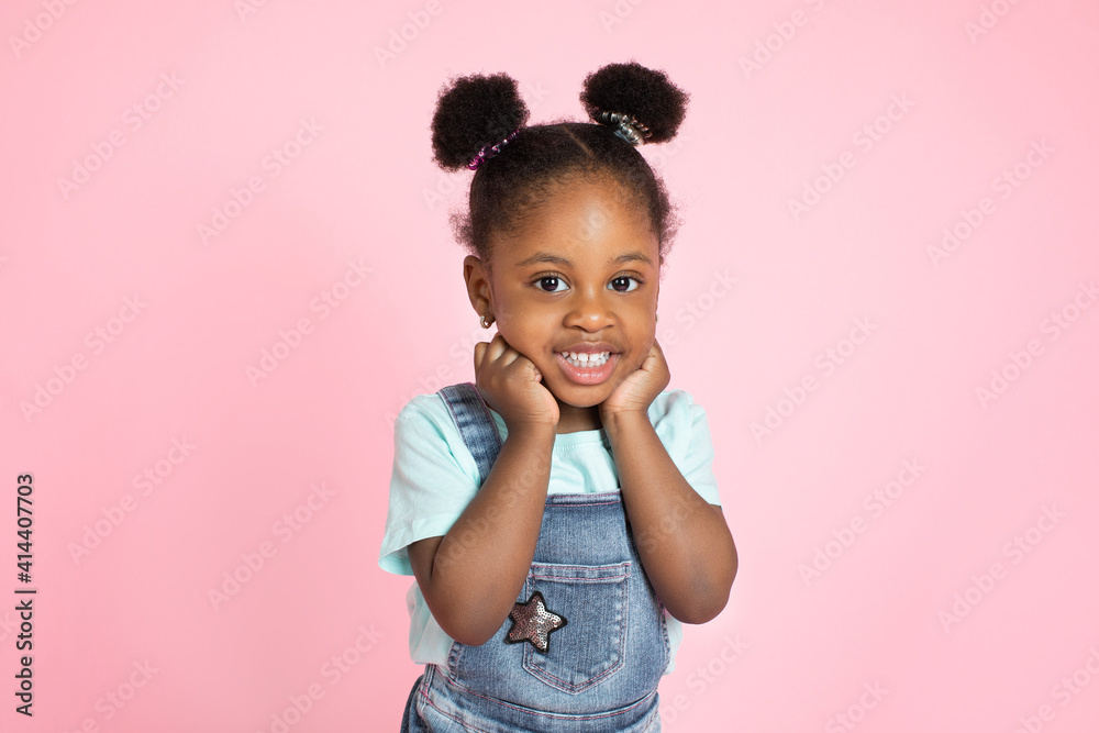 Poster funny happy smiling little cute african-american girl, with afro hair in two ponytails, posing with 