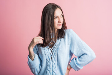 Portrait of a brunette girl on a pink background who is happy and smiling