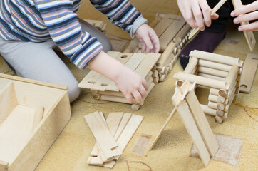 Child plays with a wooden construction set