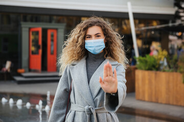 Keep your social distance. woman in virus protection face mask showing gesture Stop Infection