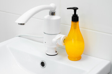 White modern faucet and a plastic bottle with soap. Faucet with electric heater.