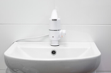 Faucet with electric heater. White modern faucet with sink