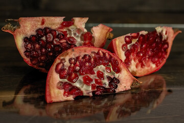 The pomegranate slices lie on a dark background.