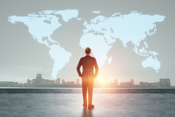 A man in a business suit, a businessman stands against the background of the world map. Concept for international business, global development, online sales.