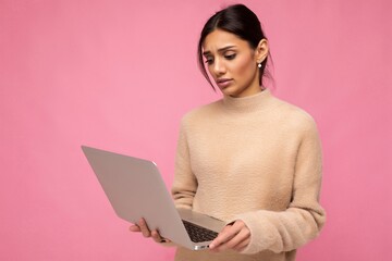side profile photo of charming pretty sad young lady holding laptop isolated over wall background looking down at netbook