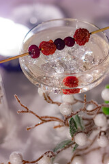 a glass of champagne with berries on a skewer