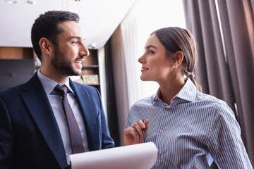 Multicultural business people with pen and paper smiling in restaurant
