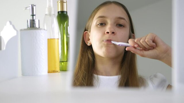 Kid Brushing Baby Teeth in Mirror, Young Child Washing using Toothbrush, Blonde Girl in Bathroom, Teenager Healthcare