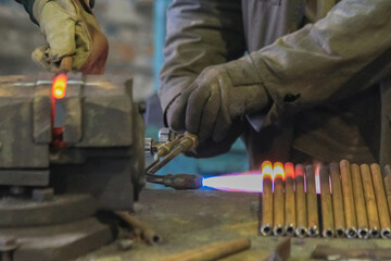 With a gas cutter, the tubes are heated on the metal and clamped in a vice