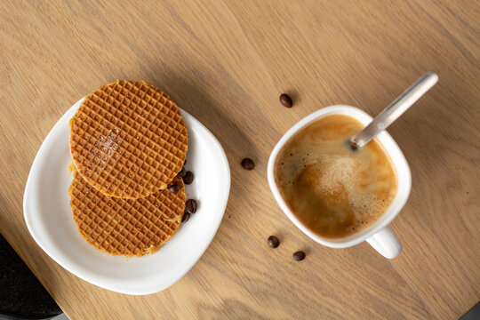 Cup of coffee with stroopwafers and spoon in cup