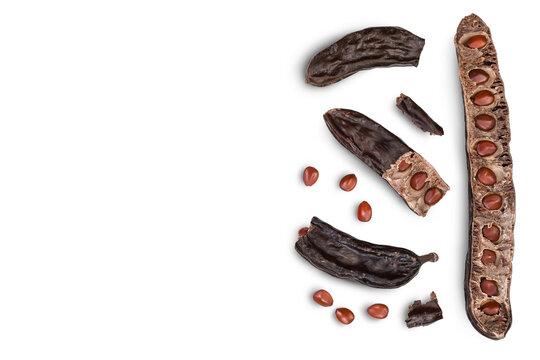 Ripe carob pods and bean isolated on white background with clipping path. Top view with copy space for your text. Flat lay
