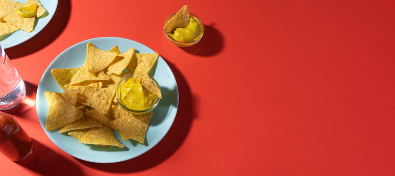 Nachos Chips With Cheese Sauce On Blue Plate On Red Background With Copy Space. Food Photo Banner Format. Concept Roadside Cafe Or Truck Stop Fast Food