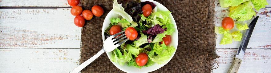 Zenith view, assorted salad in white bowl, with cherry tomatoes.